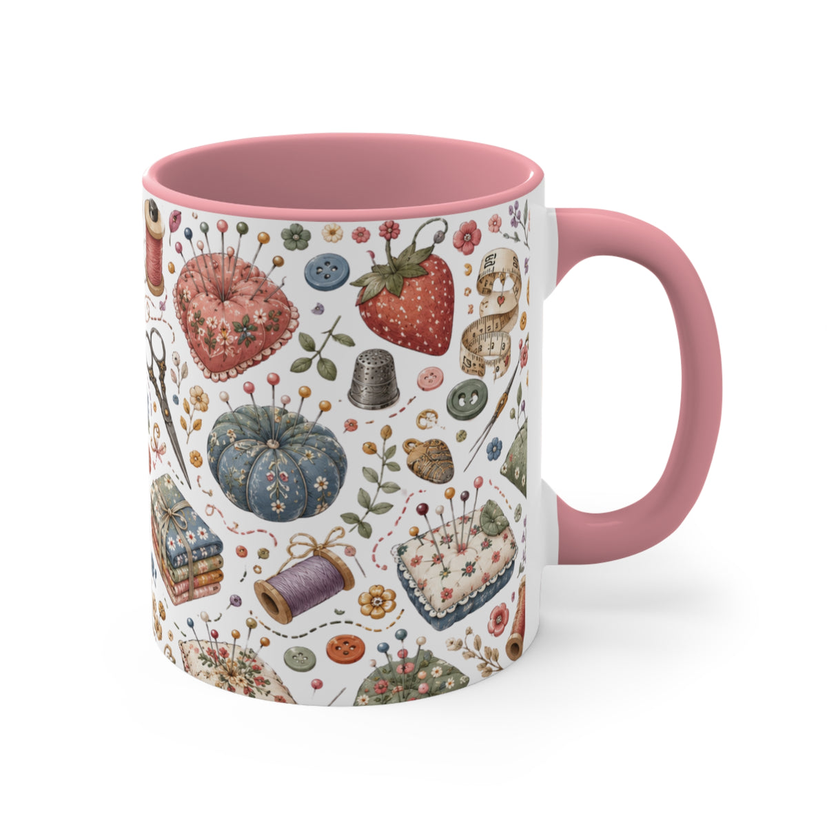 A white ceramic mug with a pink interior and handle, decorated with a vintage-style sewing and crafting pattern featuring a strawberry, thimble, buttons, and thread spools.