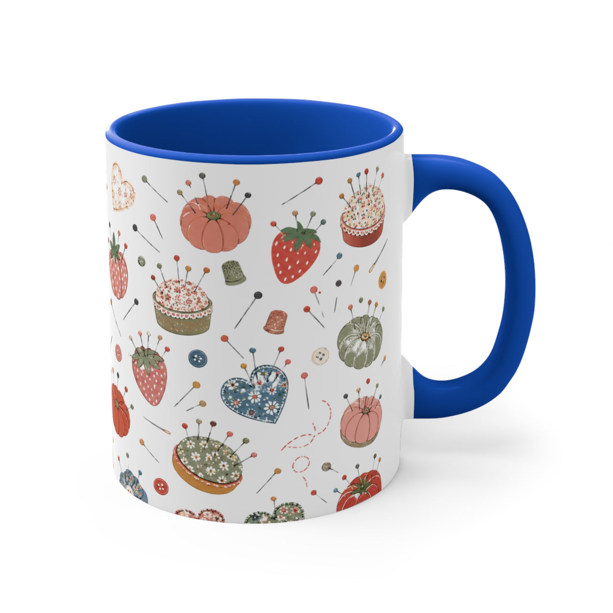 A white ceramic mug with a blue handle and blue interior, decorated with a vintage-style sewing and pi cushion pattern featuring strawberries, pincushions, and sewing notions.