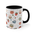 A white ceramic mug with a black handle and black interior, decorated with a vintage-style sewing and pin cushion pattern featuring strawberries, pincushions, and sewing notions.
