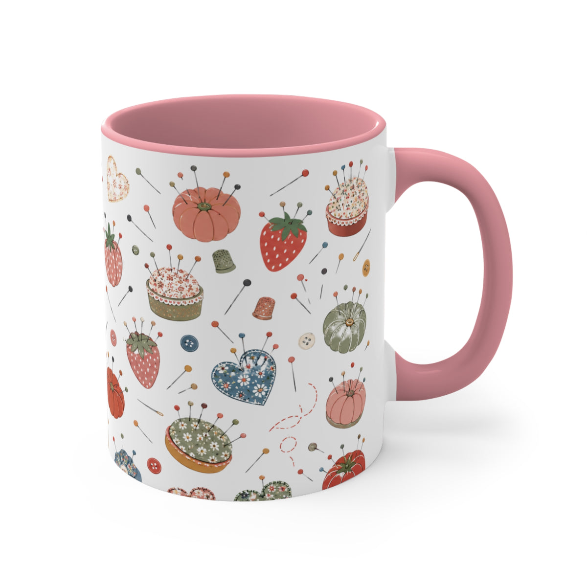 A white ceramic mug with a pink handle and pink interior, decorated with a whimsical pattern of strawberries, cupcakes, pins, and sewing notions on a white background.