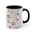 A white ceramic mug with a black interior, decorated with a vintage-style sewing and crafting pattern featuring pink roses, thread spools and fabric. The handle is on the right.