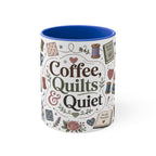 A white ceramic mug with a blue handle and blue interior, with the words 'Coffee, Quilts & Quiet' in the centre. It is decorated with quilting-themed illustrations including fabric stacks, sewing spools, a coffee cup, and quilt patterns on a white background. The handle is not visible.