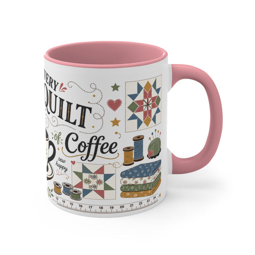 A white ceramic mug with a pink handle and interior, decorated with quilting-themed illustrations and the text 'Behind Every Great Quilt is a Strong Cup of Coffee'. The handle is on the right.