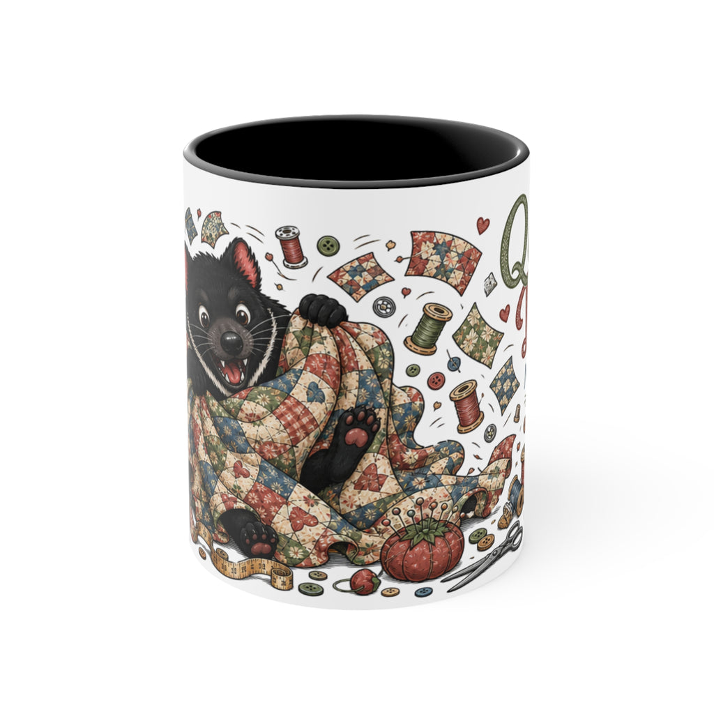 A white ceramic mug with a black interior, featuring a whimsical illustration of a Tasmanian Devil wrapped in a patchwork quilt surrounded by sewing spools, fabric scraps, and hearts.