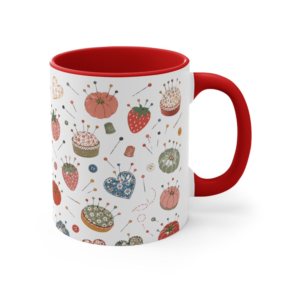 A white ceramic mug with a red handle and red interior, decorated with a vintage-style sewing and pin cushion pattern featuring strawberries, pincushions, and sewing notions.
