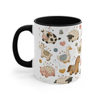 A white ceramic mug with a black handle and interior, decorated with a whimsical pincushion animals including chickens, pigs, ducks, horses, sheep, and goats. The handle is on the left.