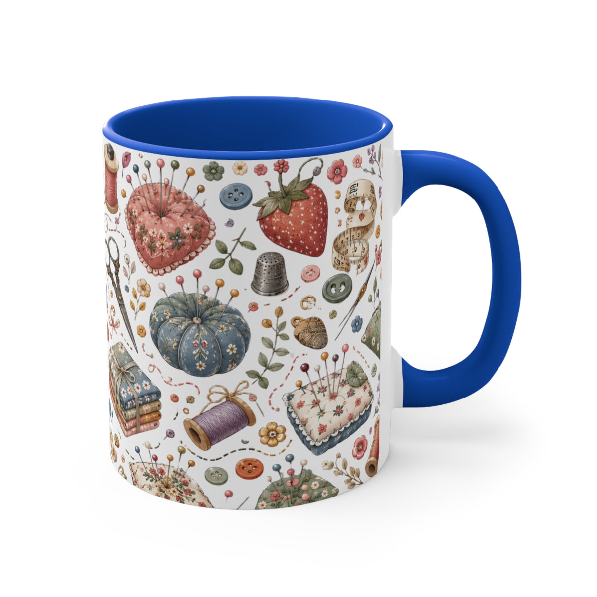 A white ceramic mug with a vibrant blue handle and interior, decorated with a vintage-style sewing and needlework pattern featuring a strawberry, pincushion, thimble, and thread spools.