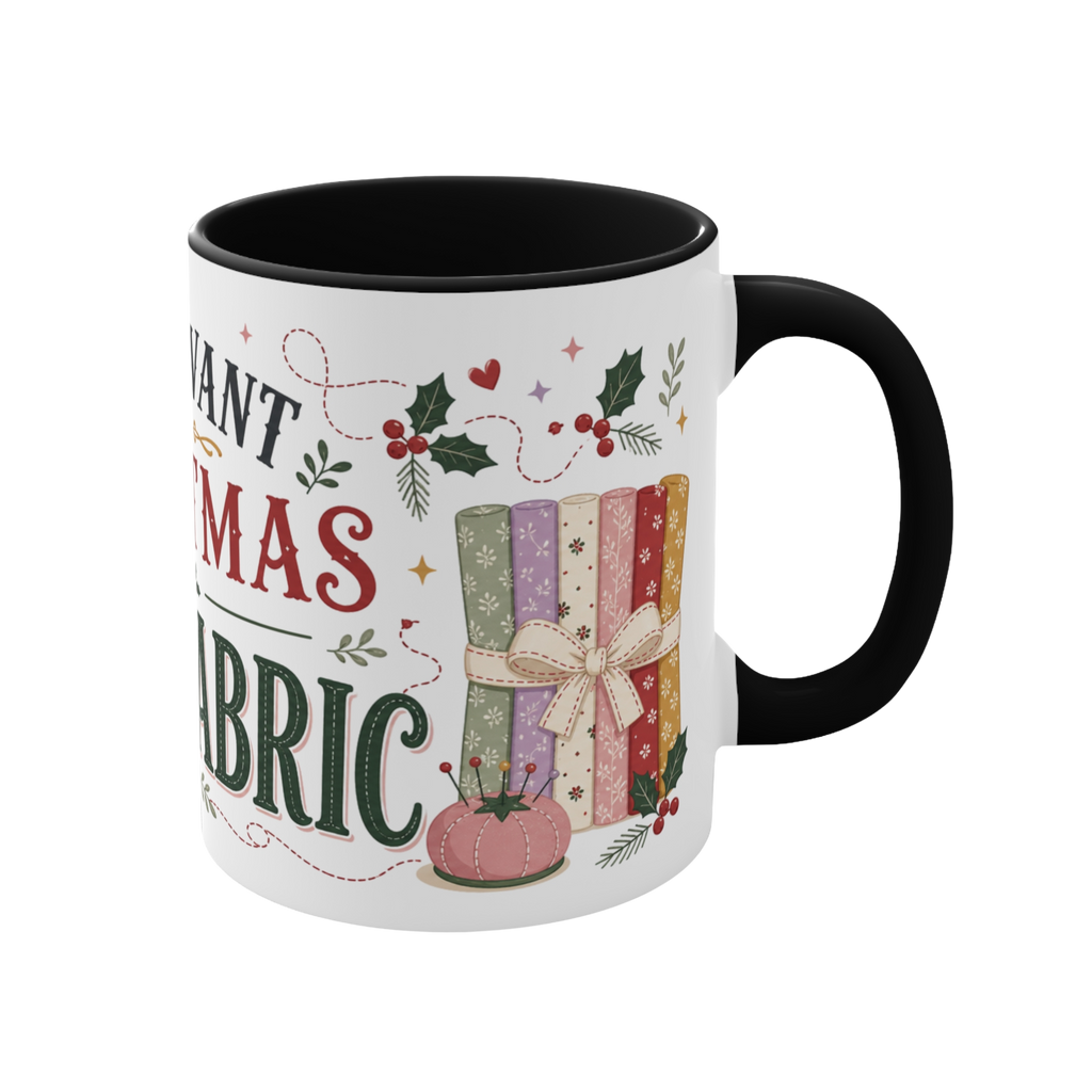 The right side of a white ceramic mug with a black handle and interior, decorated with a bundle of fabric, a pincushion and holly. The text 'All I Want for Christmas is More Fabric' is partially visible.