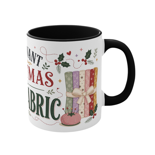 The right side of a white ceramic mug with a black handle and interior, decorated with a bundle of fabric, a pincushion and holly. The text 'All I Want for Christmas is More Fabric' is partially visible.