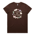 A dark brown short-sleeve crewneck t-shirt featuring a circular graphic on the chest with the text 'A Little Bit Scrappy' surrounded by small colorful fabric pieces.