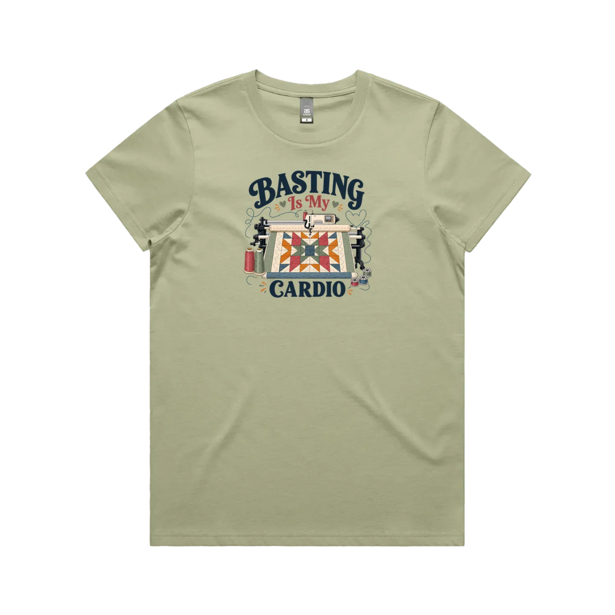 A pistachio green short-sleeve t-shirt featuring the words 'Basting Is My Cardio' with an illustration of a longarm quilting machine, a quilt and thread.