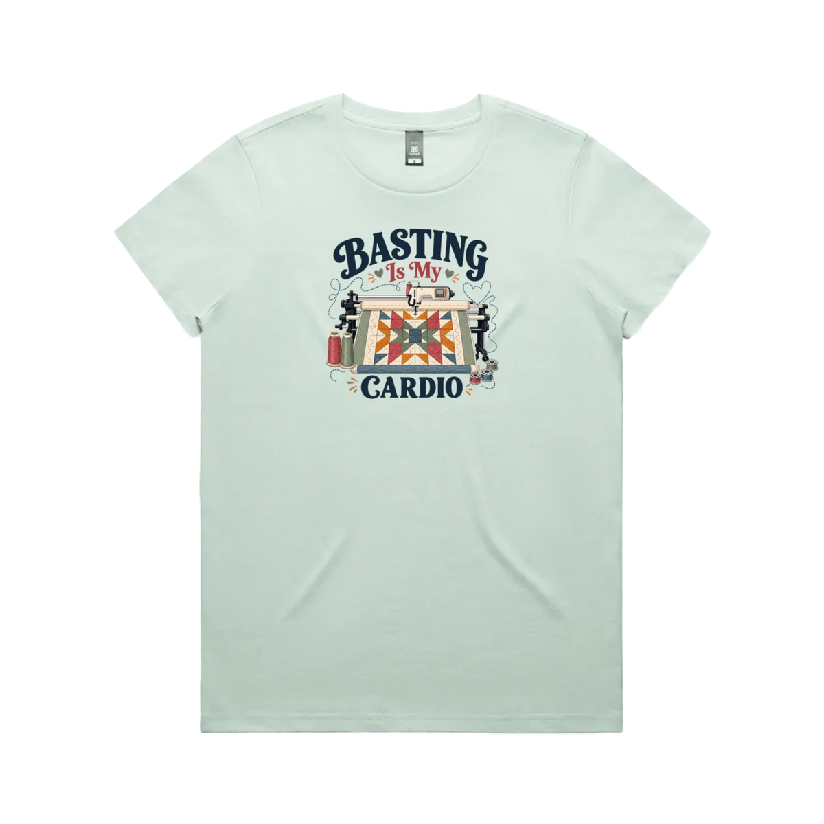 A pale mint green short-sleeve t-shirt featuring the words 'Basting Is My Cardio' with an illustration of a longarm quilting machine, a quilt and thread.