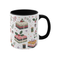 The right side of a white ceramic mug with a black handle and interior, decorated with a repeating pattern of stacked fabrics, holly leaves, berries, and thread spools in soft pink, green, beige, and brown tones.