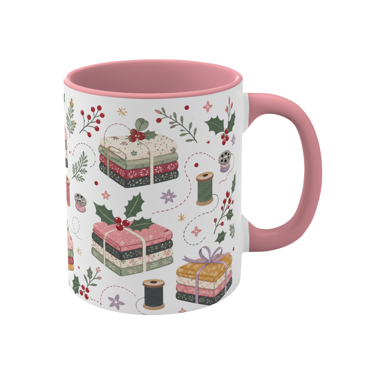 The right side of a white ceramic mug with a pink handle and interior, decorated with a repeating pattern of stacked fabrics, holly leaves, berries, and thread spools in soft pink, green, beige, and brown tones.