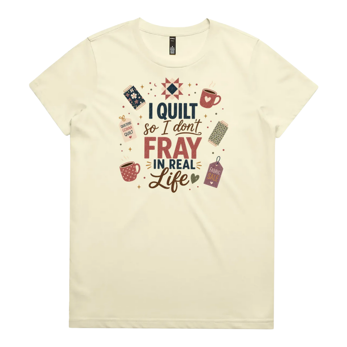 A pale butter yellow short-sleeve crewneck t-shirt featuring a colorful graphic print on the front with quilting-themed illustrations and the text 'I Quilt So I Don't Fray in Real Life'.