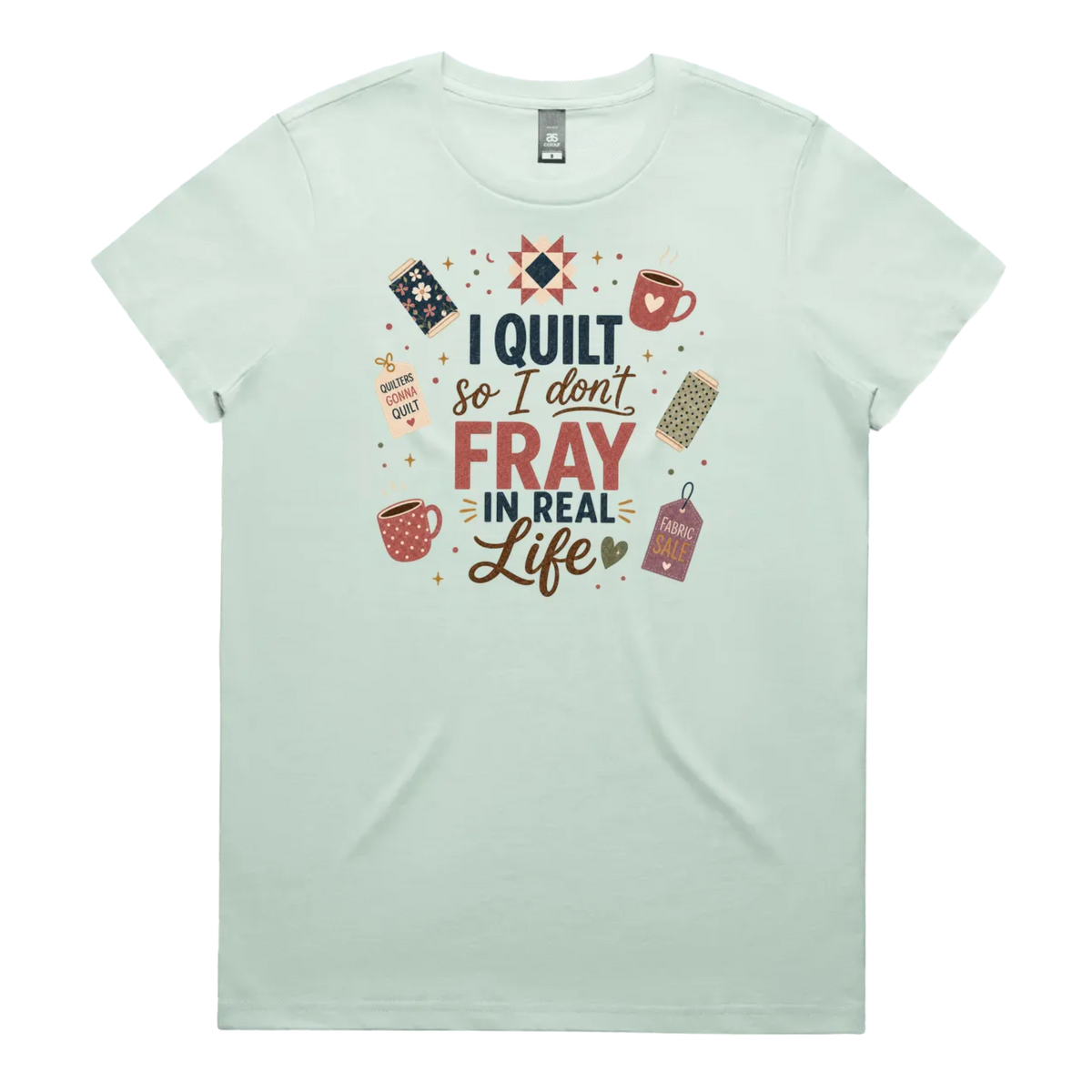 A pale mint green short-sleeve crewneck t-shirt featuring a colorful graphic print on the front with quilting-themed illustrations and the text 'I Quilt So I Don't Fray in Real Life'.