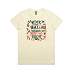 A pale butter yellow short-sleeve crewneck t-shirt featuring a colorful graphic print on the front with sewing-themed illustrations and the text 'Deck the Halls and the Sewing Room'.
