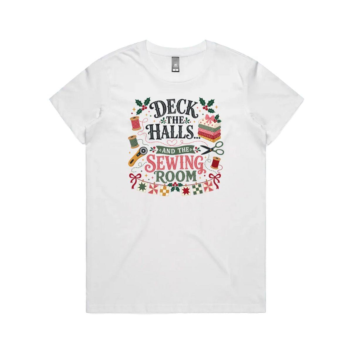 A white short-sleeve crewneck t-shirt featuring a colorful graphic print on the front with sewing-themed illustrations and the text 'Deck the Halls and the Sewing Room'.