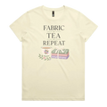 A pale butter yellow short-sleeve crewneck t-shirt featuring a graphic print that reads 'FABRIC, TEA, REPEAT' above an illustration of a teacup, floral details, and patterned fabric stack.