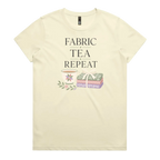 A pale butter yellow short-sleeve crewneck t-shirt featuring a graphic print that reads 'FABRIC, TEA, REPEAT' above an illustration of a teacup, floral details, and patterned fabric stack.