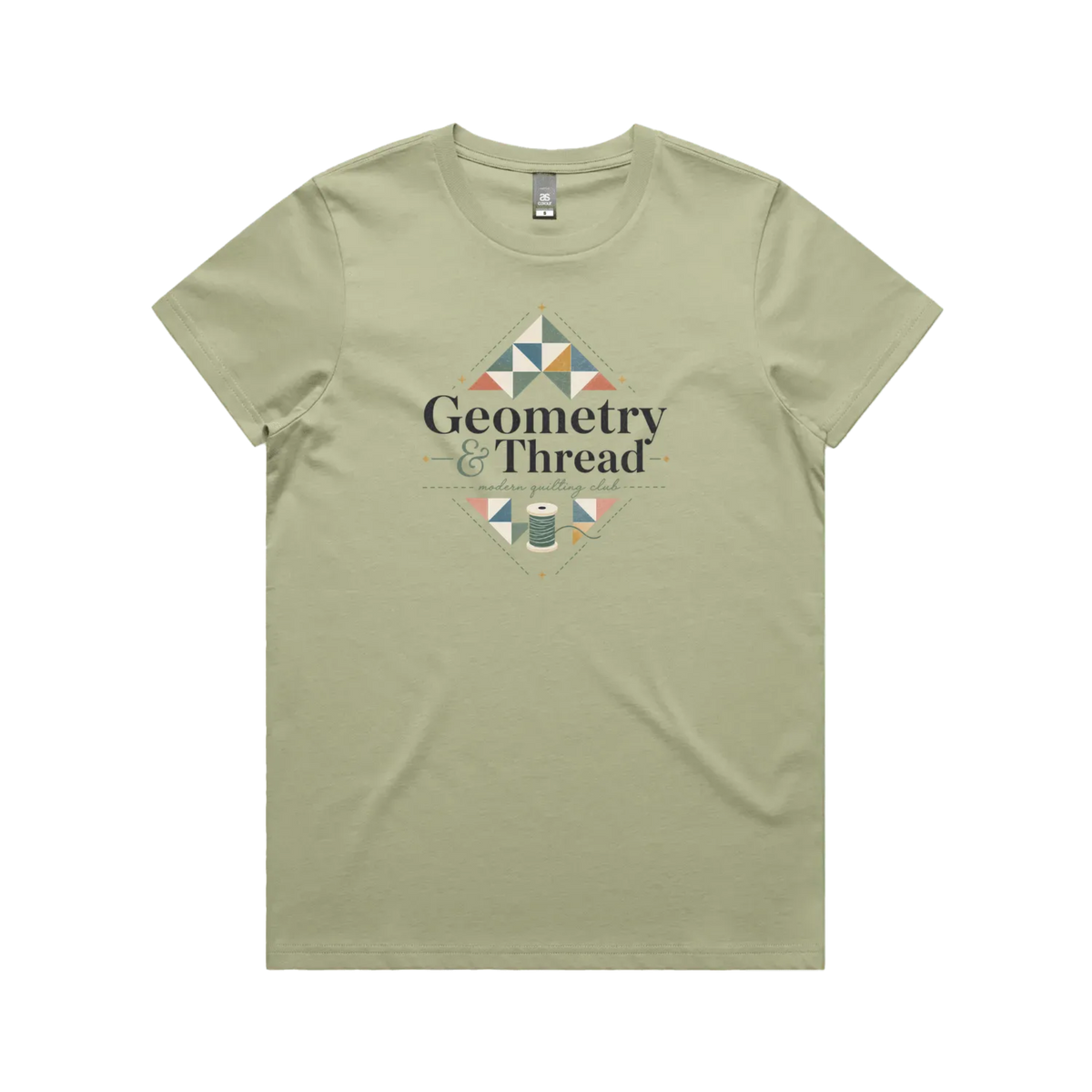 A pistachio green short-sleeve crewneck graphic t-shirt featuring the words 'Geometry & Thread, Modern Quilting Club' surrounded by patchwork triangles and a spool of thread.