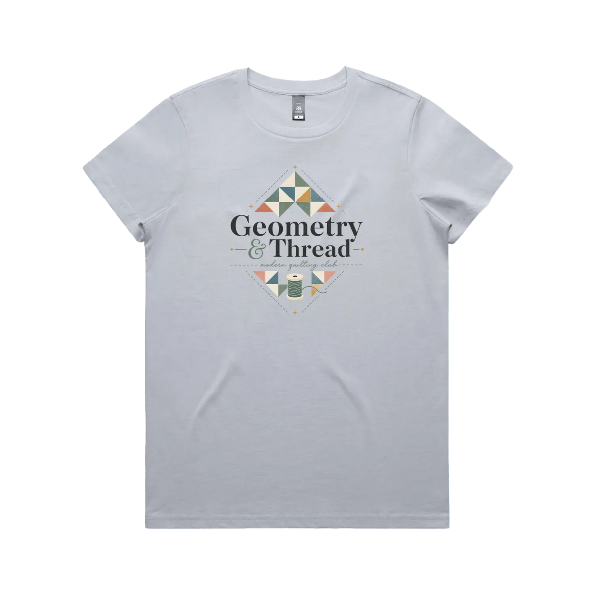 A powder blue short-sleeve crewneck graphic t-shirt featuring the words 'Geometry & Thread, Modern Quilting Club' surrounded by patchwork triangles and a spool of thread.