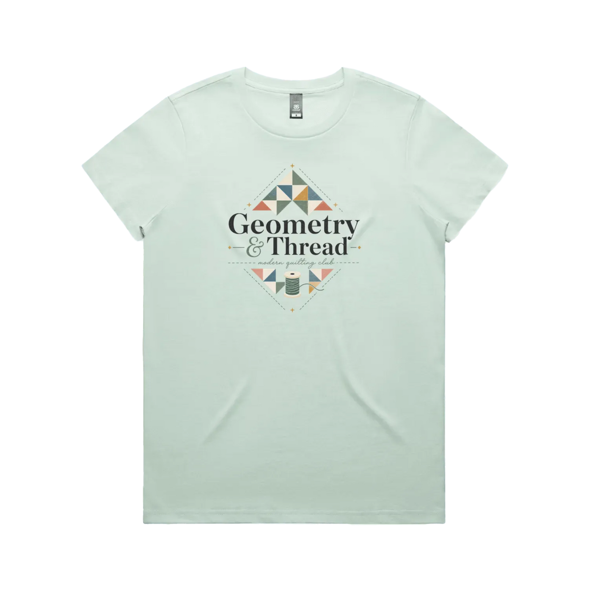 A pale mint green short-sleeve crewneck graphic t-shirt featuring the words 'Geometry & Thread, Modern Quilting Club' surrounded by patchwork triangles and a spool of thread.