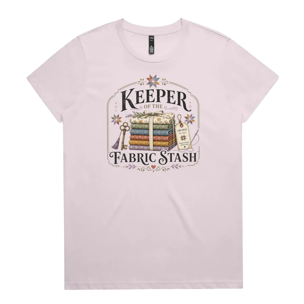 A pale mauve crewneck, short-sleeved t-shirt with the vintage style graphic 'Keeper of the Fabric Stash'.