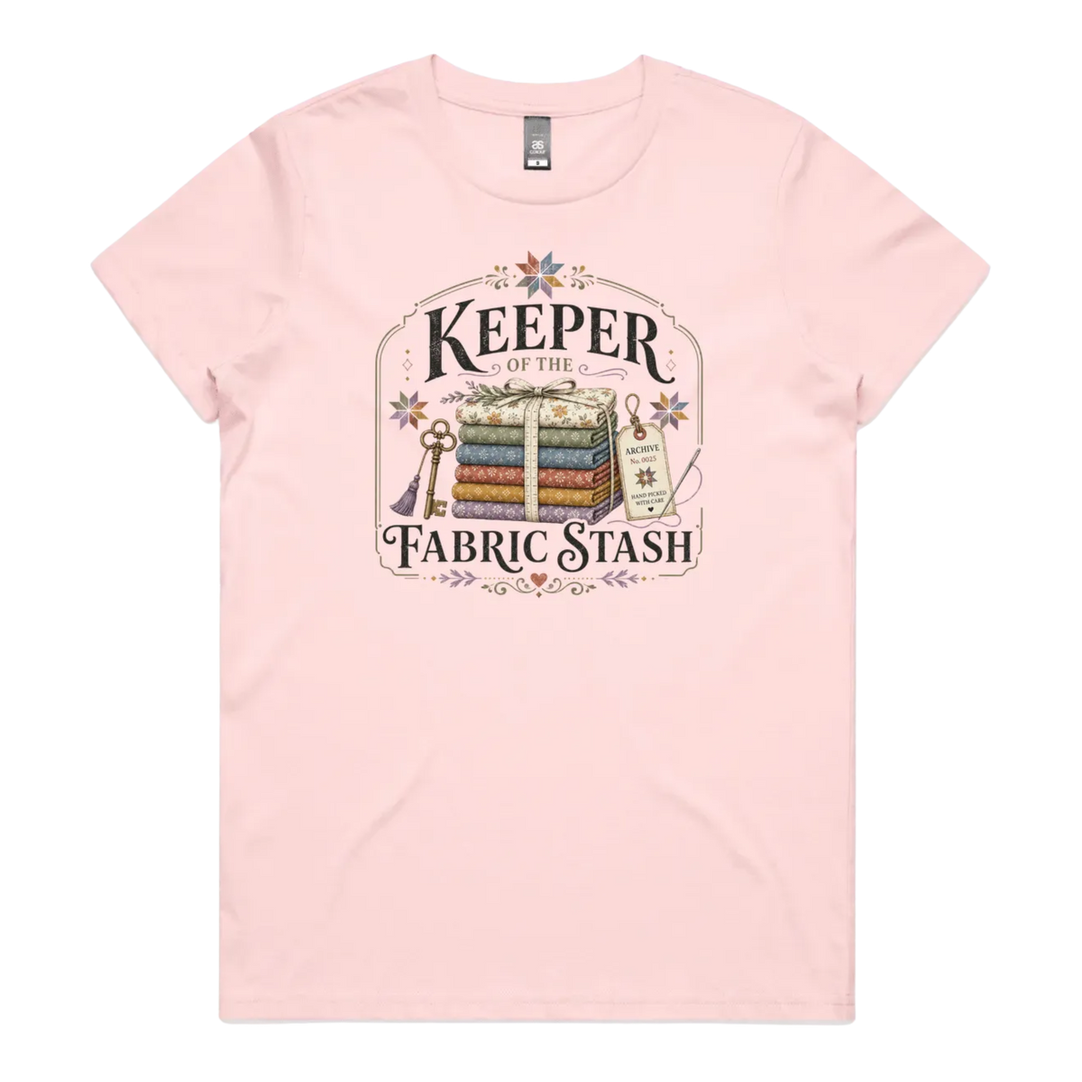 A pale pink crewneck, short-sleeved t-shirt with the vintage style graphic 'Keeper of the Fabric Stash'.