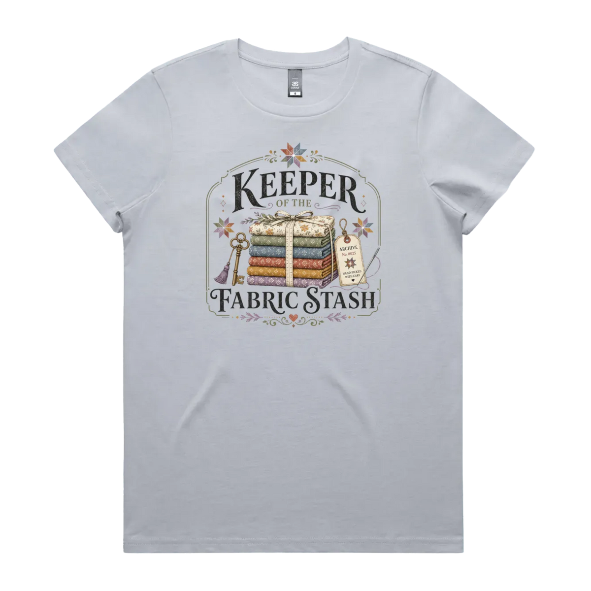 A powder blue crewneck, short-sleeved t-shirt with the vintage style graphic 'Keeper of the Fabric Stash'.