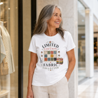 An older woman with shoulder length grey hair stands outside a shop in a mall wearing the 'Limited Edition Fabric Collector' t-shirt in white.