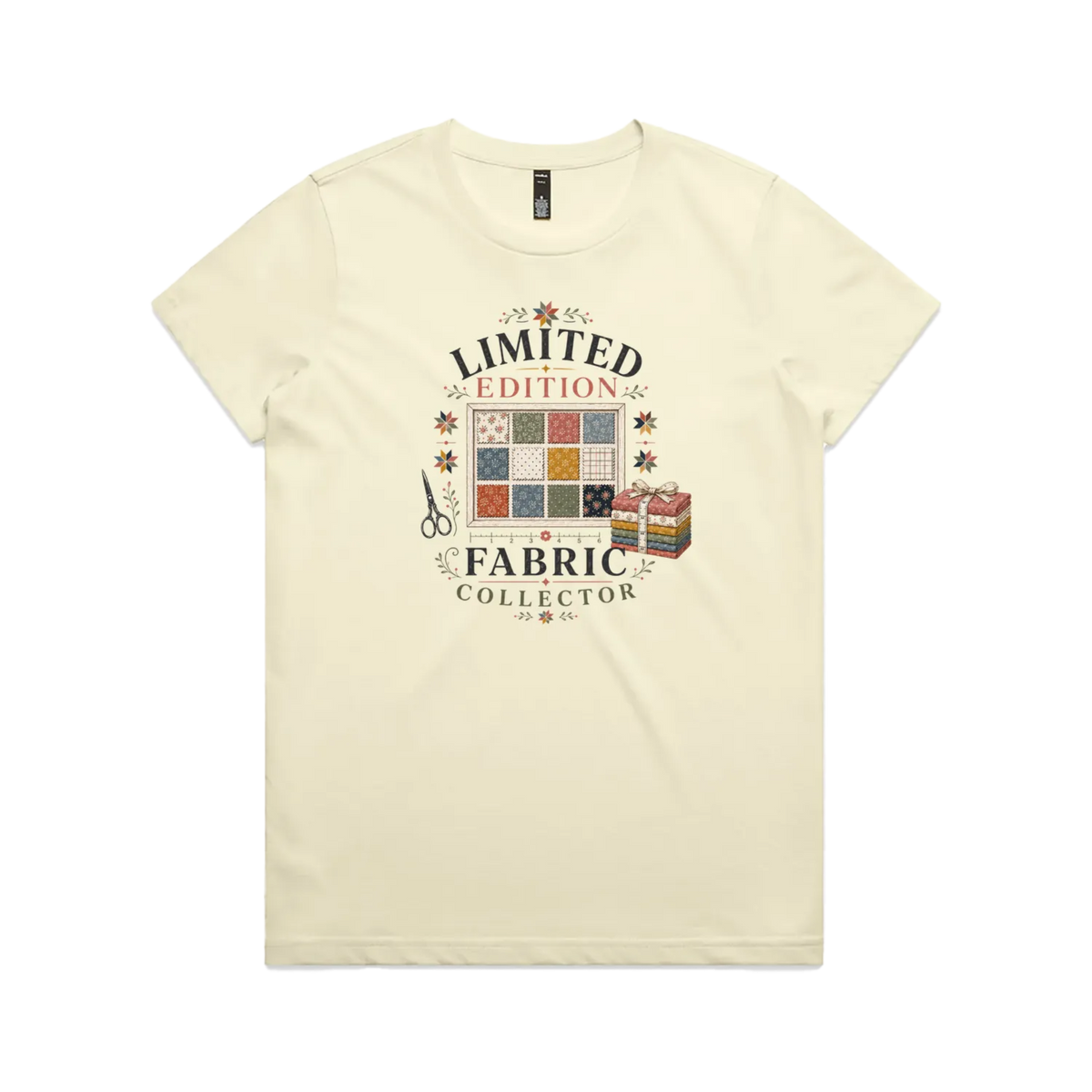 A pale butter yellow short-sleeve crewneck t-shirt featuring the text 'Limited Edition Fabric Collector' surround a fabric swatch board, a tied bundle of fabric and scissors.