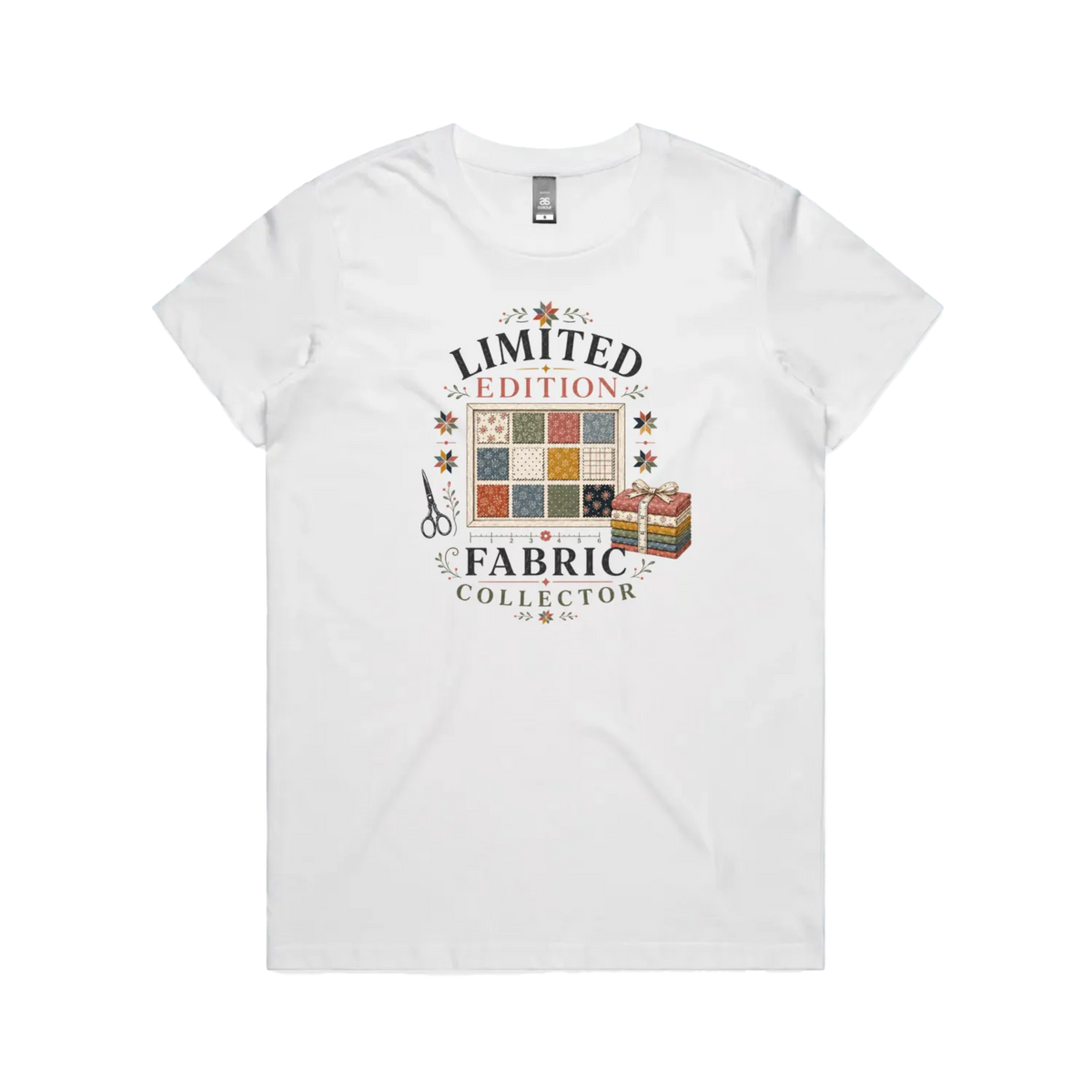 A white short-sleeve crewneck t-shirt featuring the text 'Limited Edition Fabric Collector' surround a fabric swatch board, a tied bundle of fabric and scissors.