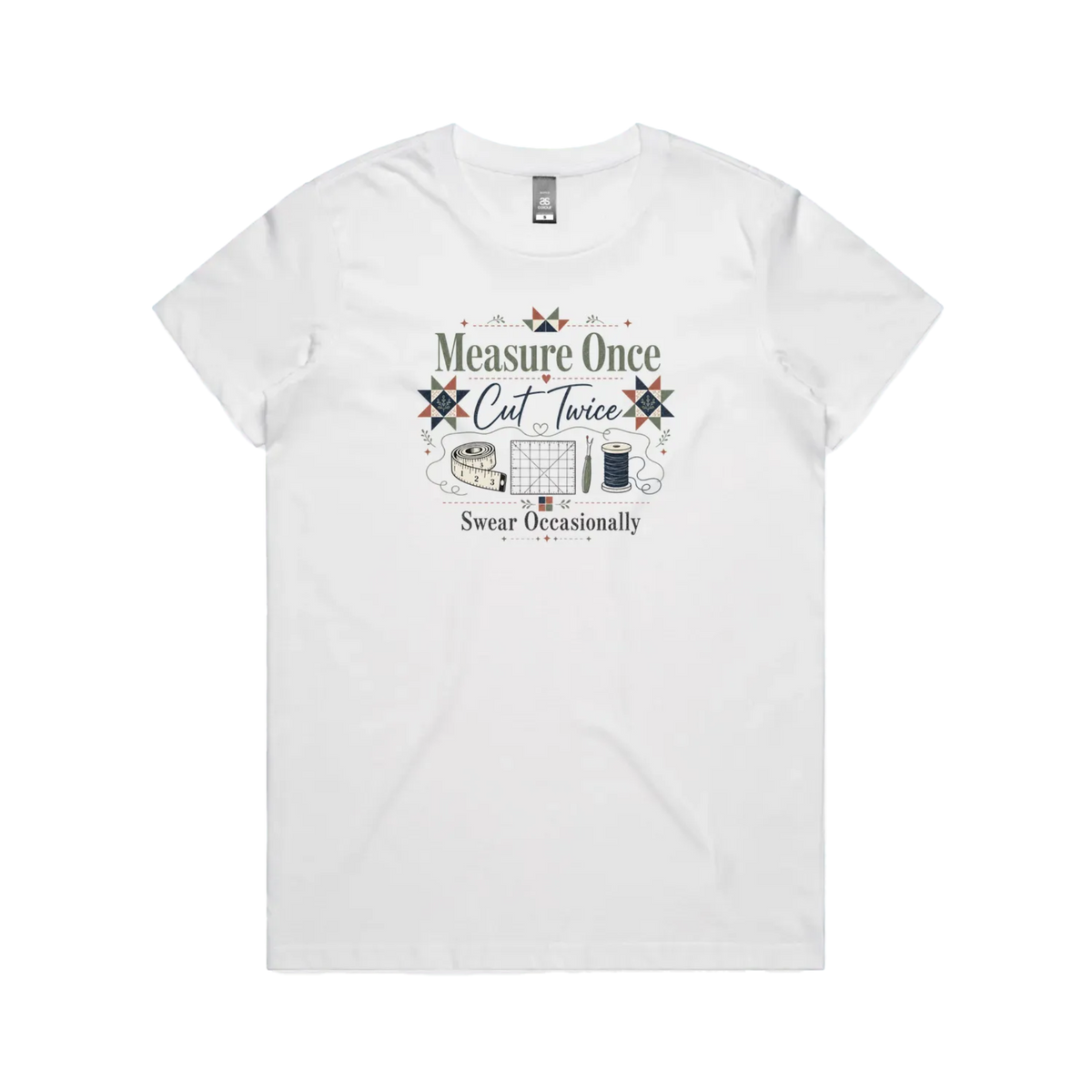 A white short-sleeve crewneck t-shirt with the graphic 'Measure Once, Cut Twice, Swear Occasionally'. The design includes patchwork stars and quilting accessories.
