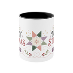 The front of a white ceramic mug with a black interior decorated with a festive quilt star, stitch lines, leaves and berries.