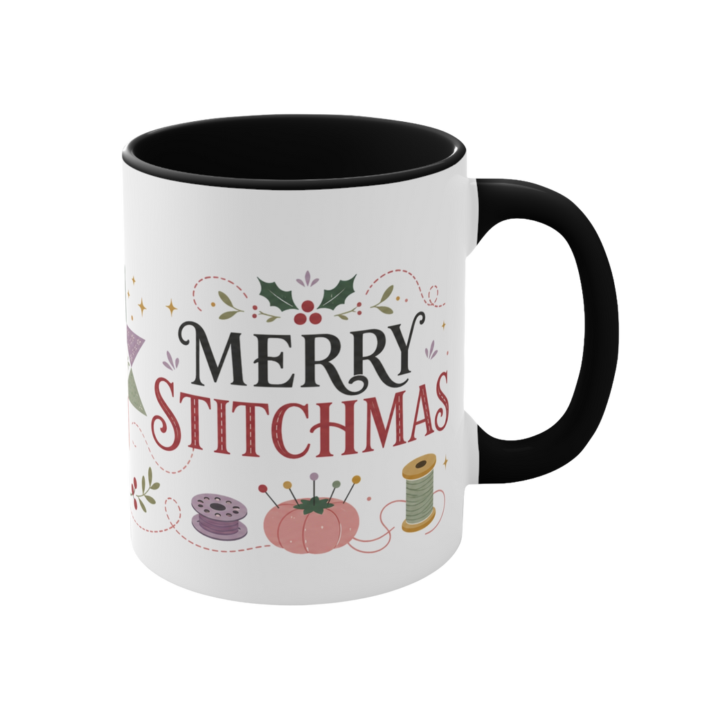 The right side of a white ceramic mug with a black handle and interior, decorated with a bobbin, thread spool,  pincushion and holly and the text ‘Merry Stitchmas’.