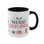 The right side of a white ceramic mug with a black handle and interior, decorated with a bobbin, thread spool,  pincushion and holly and the text ‘Merry Stitchmas’.