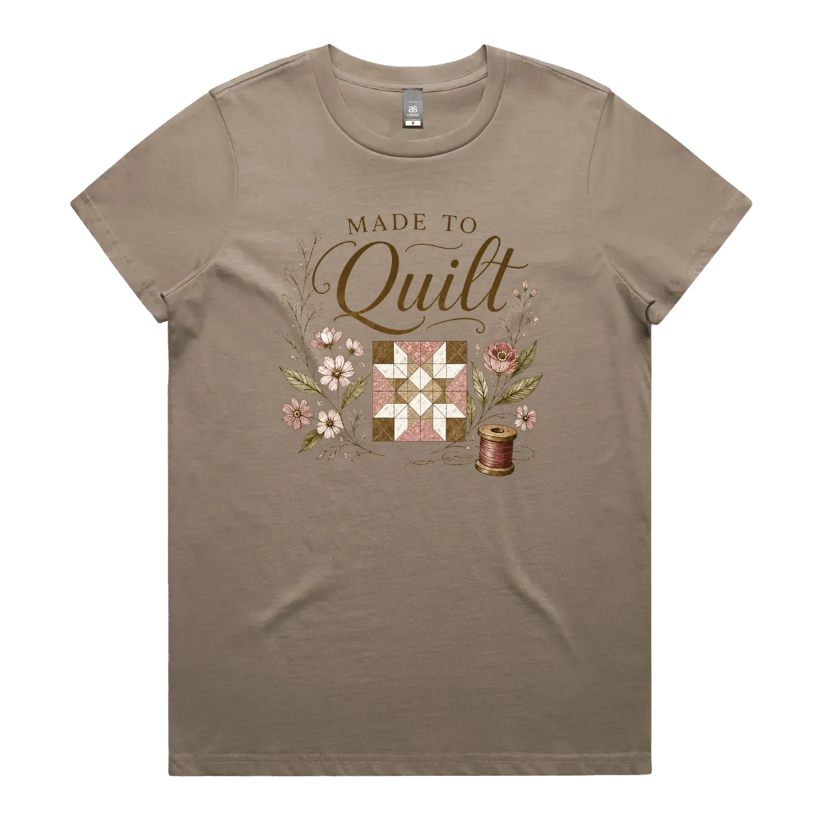 A mushroom brown short-sleeve crewneck t-shirt featuring a vintage-style quilt graphic with the text 'Made To Quilt' in brown script and floral illustrations.