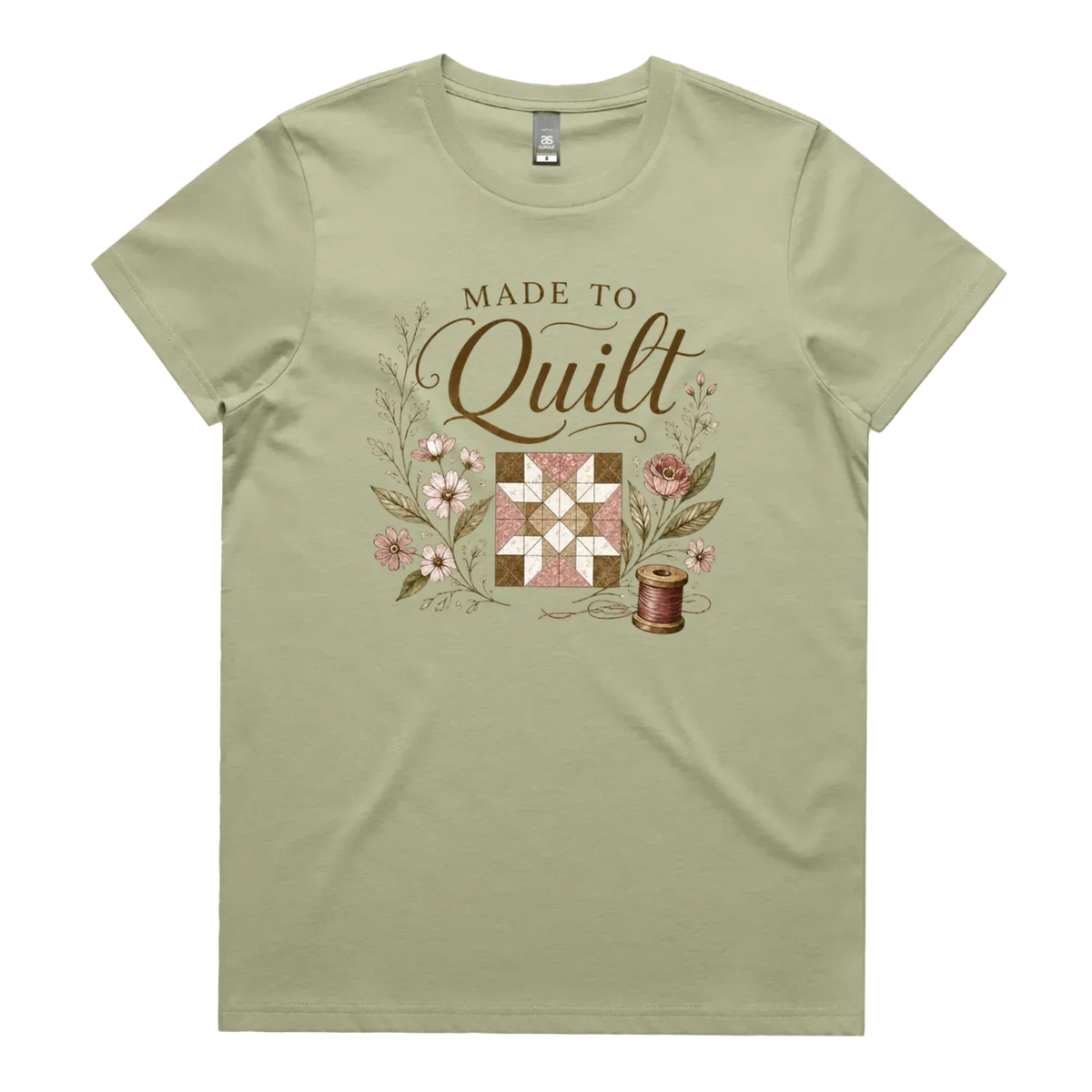 A light pistachio green short-sleeve crewneck t-shirt featuring a vintage-style quilt graphic with the text 'Made To Quilt' in brown script and floral illustrations.