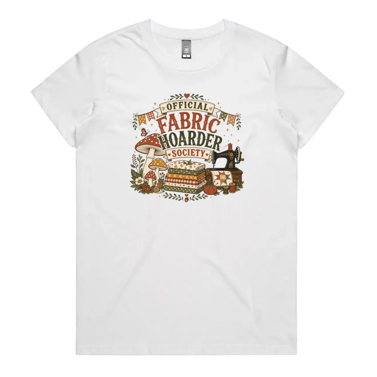A white crewneck short-sleeved t-shirt with the words 'Official Fabric Hoarder Society' above an illustration of a stack of fabric, a sewing machine and a group of muchrooms, flowers and a snail.