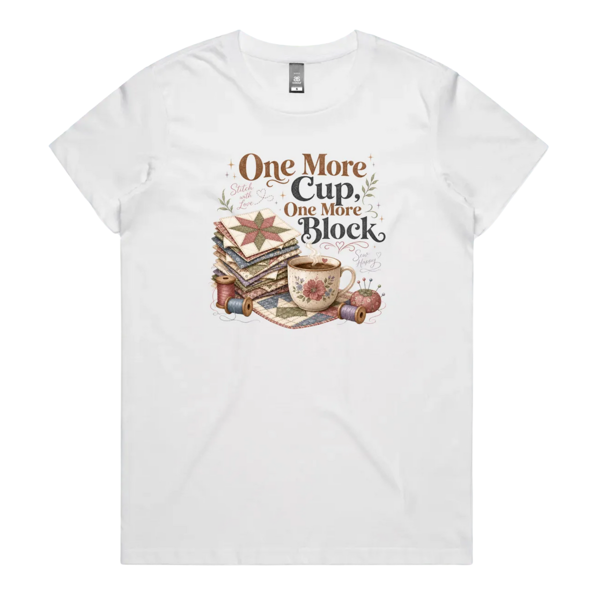 A white short-sleeve crewneck t-shirt featuring a vintage-style graphic of stacked quilt blocks, a coffee cup, and thread spools with the text 'One More Cup, One More Block' in brown and black lettering.