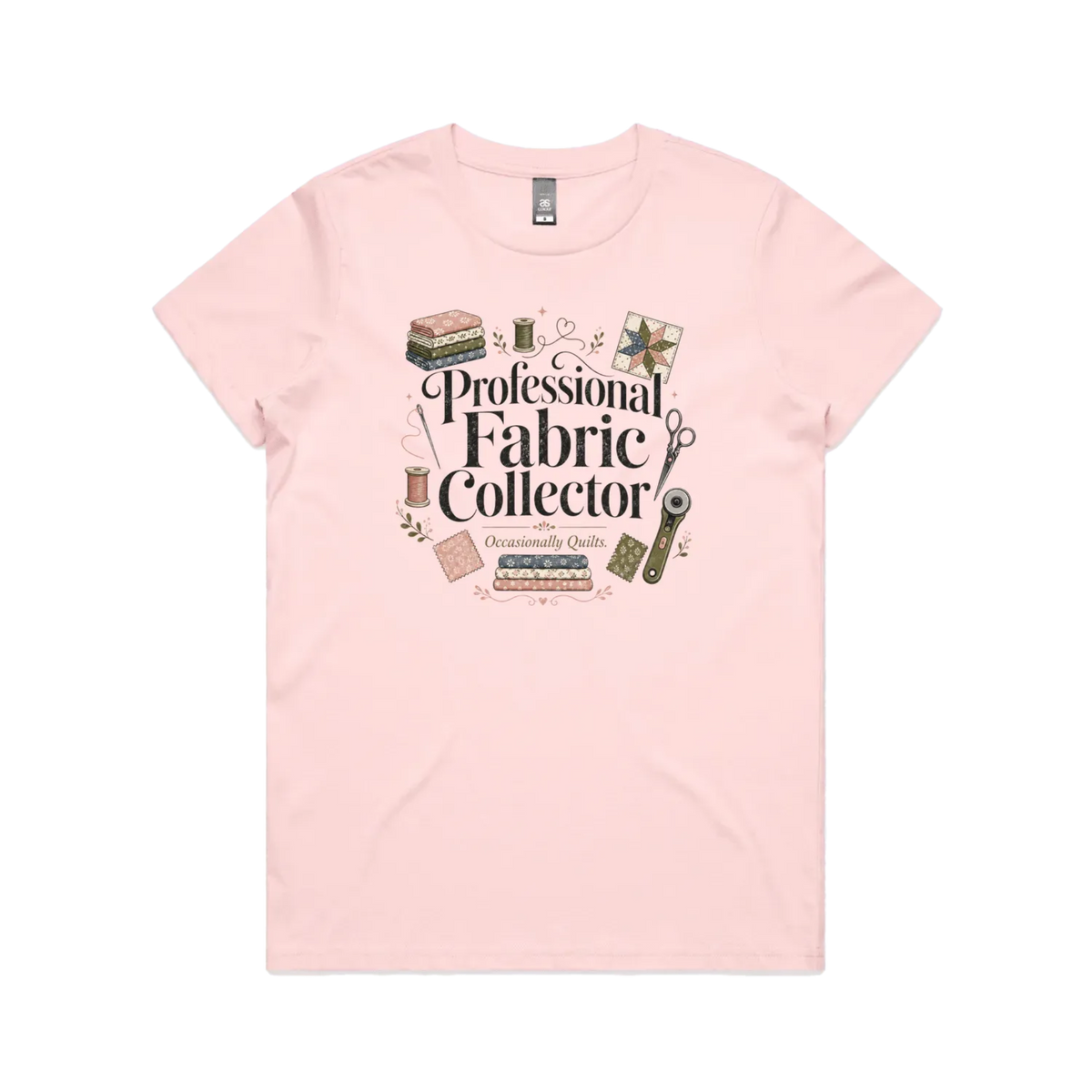 A pale pink short-sleeve crewneck t-shirt with the words 'Professional Fabric Collector' surrounded by fabric bundles, swatches, thread and a patchwork star.