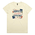 A pale butter yellow short-sleeve crewneck t-shirt featuring a colorful graphic print on the front with the text 'Perfectly Imperfect Stitches' surrounded by sashiko-themed illustrations.