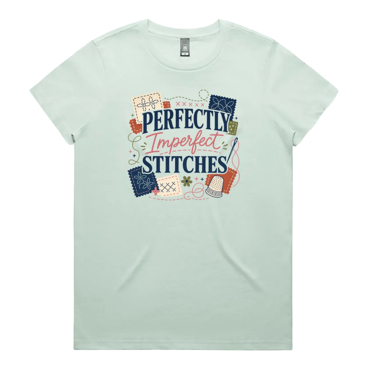 A pale mint green short-sleeve crewneck t-shirt featuring a colorful graphic print on the front with the text 'Perfectly Imperfect Stitches' surrounded by sashiko-themed illustrations.