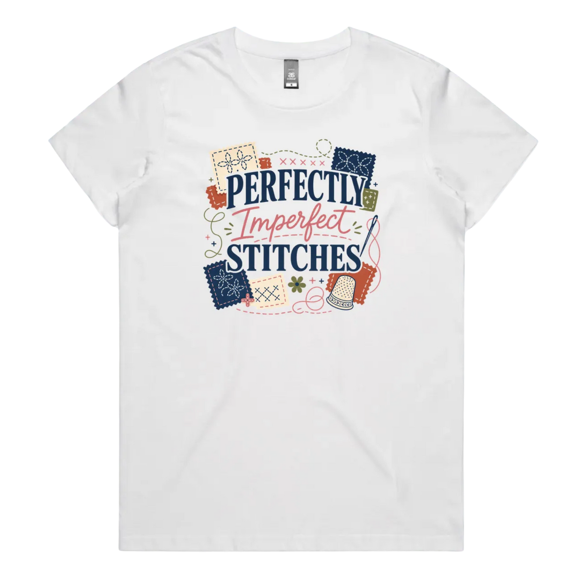 A white short-sleeve crewneck t-shirt featuring a colorful graphic print on the front with the text 'Perfectly Imperfect Stitches' surrounded by sashiko-themed illustrations.