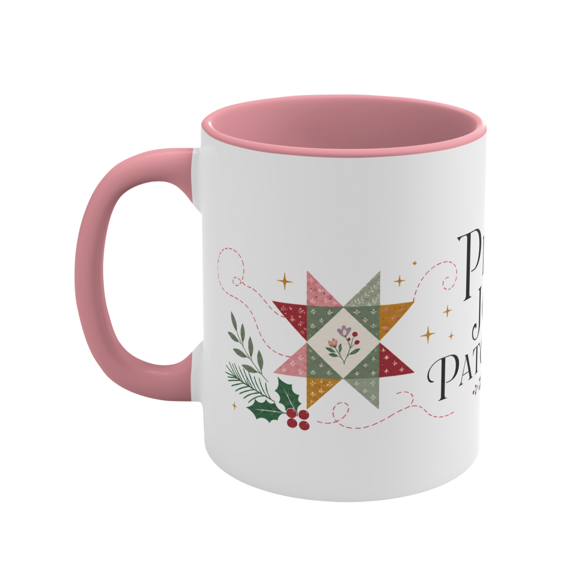 The left side of a white ceramic mug with a pink handle and interior, decorated with a quilt block, stitch lines and holly. The text ‘Peace, Joy & Patchwork' is partially visible.