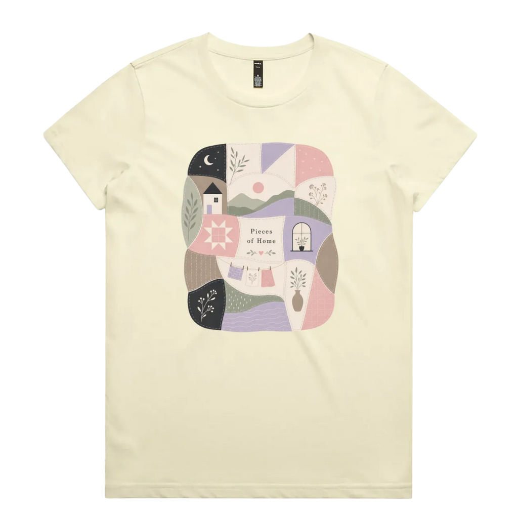 A very pale yellow short-sleeve crewneck t-shirt featuring a central square graphic with a patchwork design of pastel-colored home-themed illustrations and the text 'Pieces of Home'.