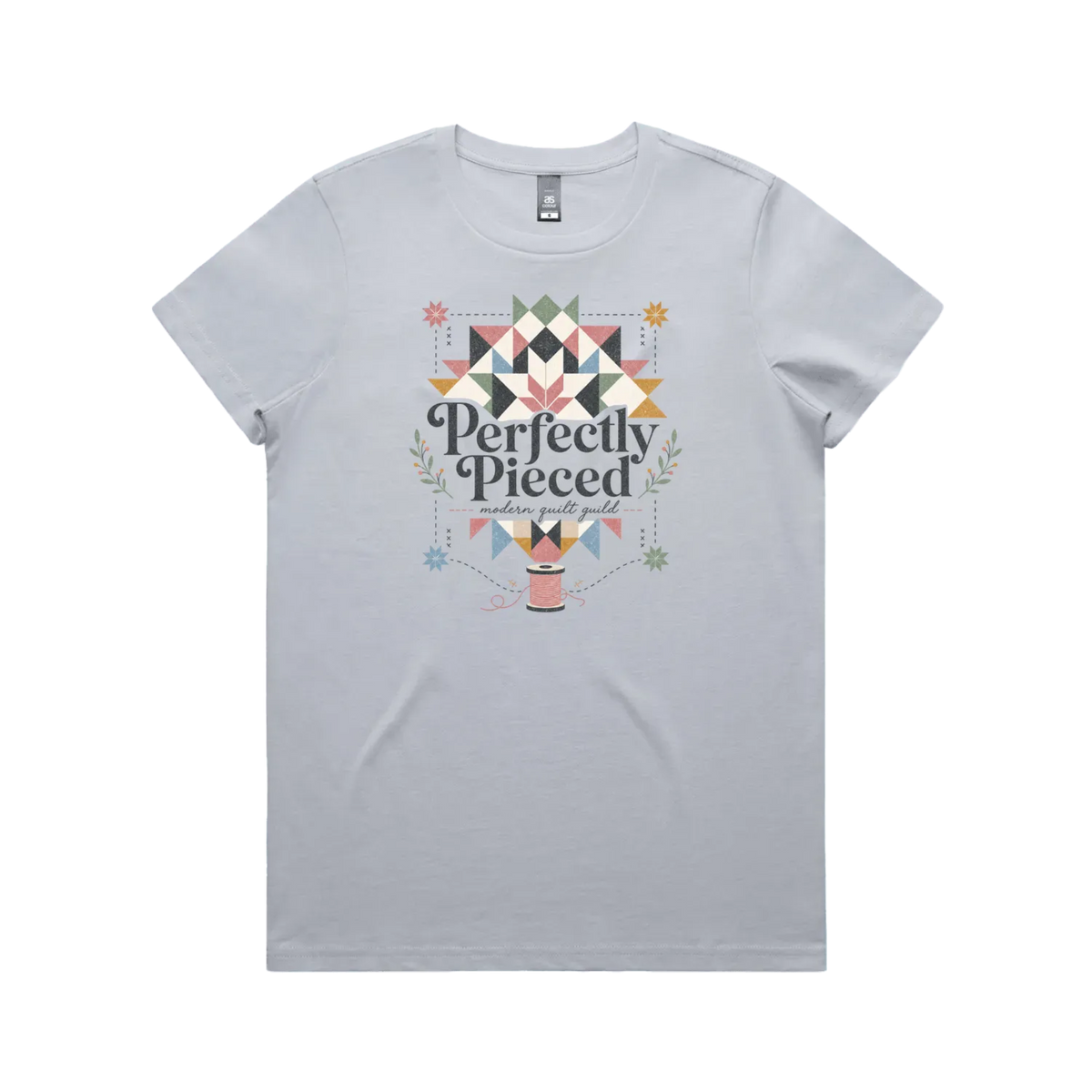 A powder blue graphic short-sleeve t-shirt with the words 'Perfectly Pieced Modern Quilt Guild' cutting through a large patchwork star.