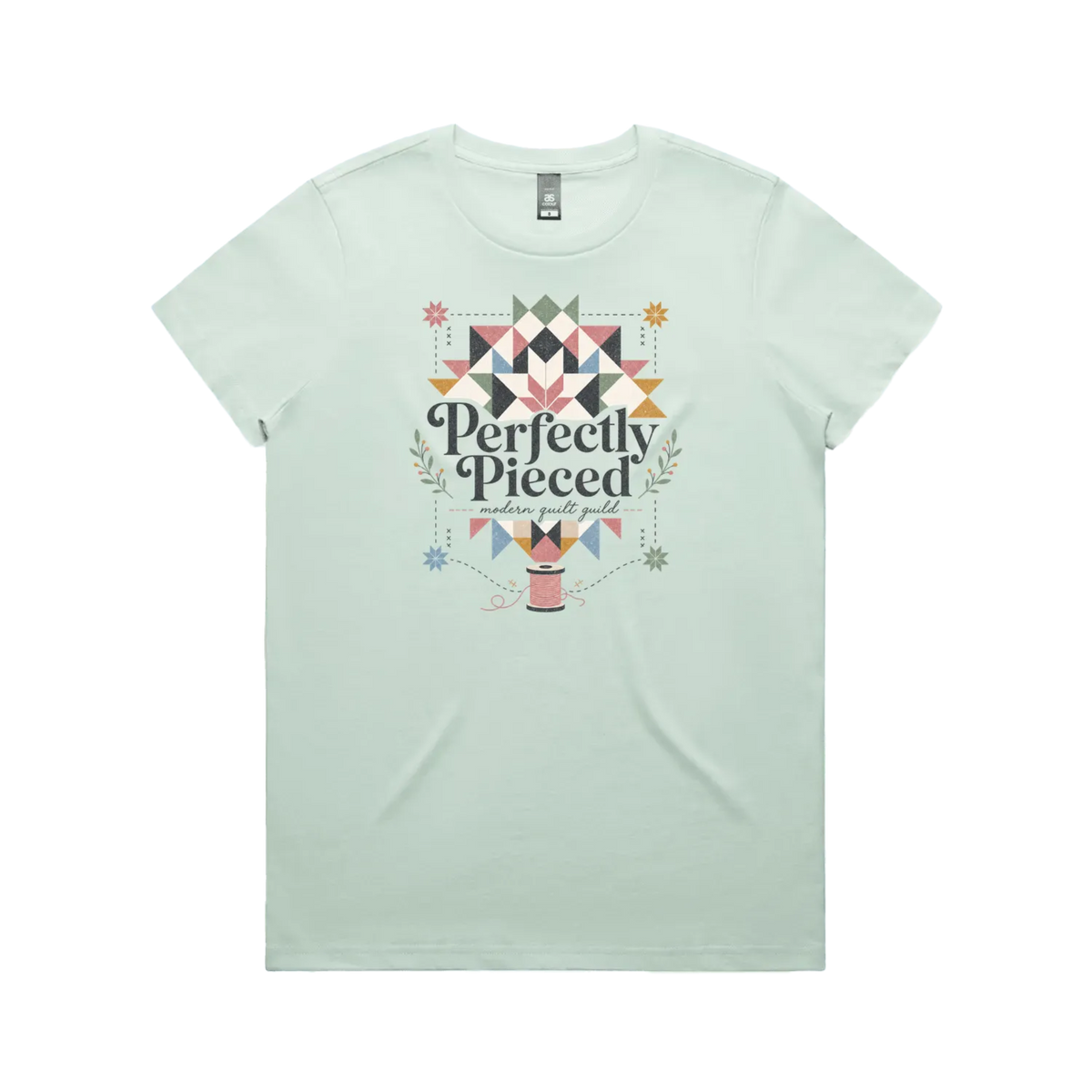 A pale mint green graphic short-sleeve t-shirt with the words 'Perfectly Pieced Modern Quilt Guild' cutting through a large patchwork star.
