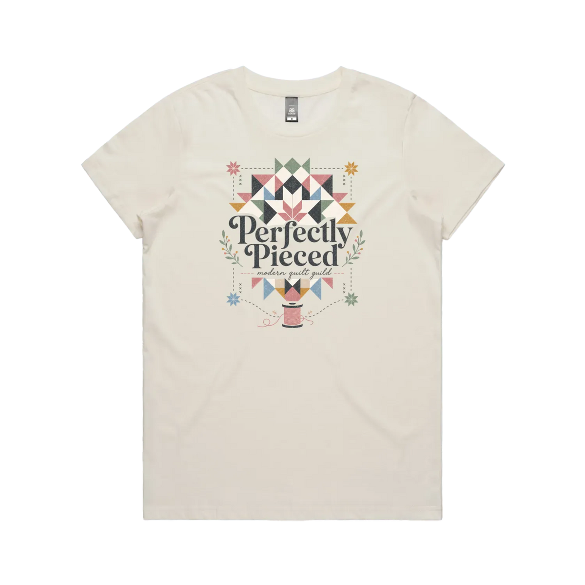 An off-white graphic short-sleeve t-shirt with the words 'Perfectly Pieced Modern Quilt Guild' cutting through a large patchwork star.